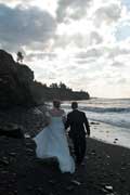 image of wedding couplewalking down beach